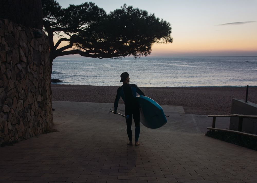 Man practicing paddle surfing with neoprene in a sunrise