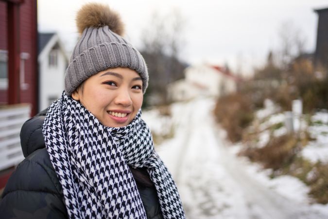 Asian female tourist in warm clothing at snowy nature