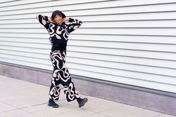 Woman in modern clothes walking along the street gesturing vitality