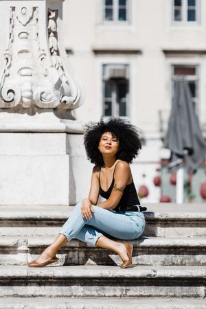 Black female siting on stairs outdoors