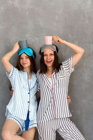 Mother and daughter in pajamas playing balancing game at sleepover.