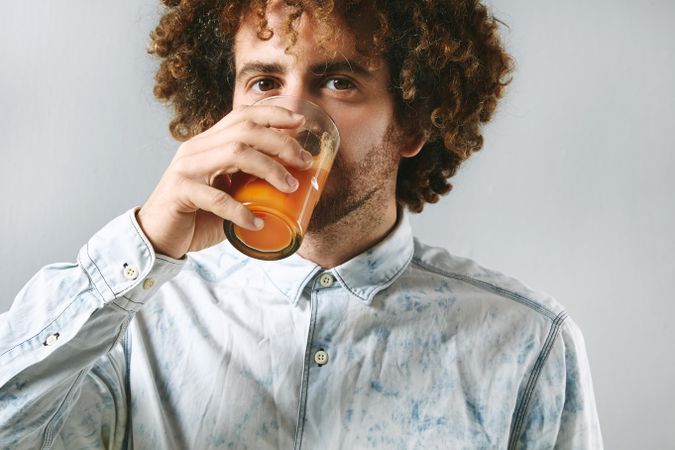 Man drinking glass of fresh carrot juice