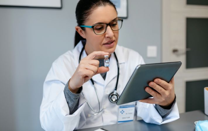 Female doctor doing online consultation showing covid-19 vaccine