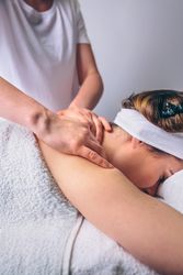 Massage therapists giving massage to client's shoulders