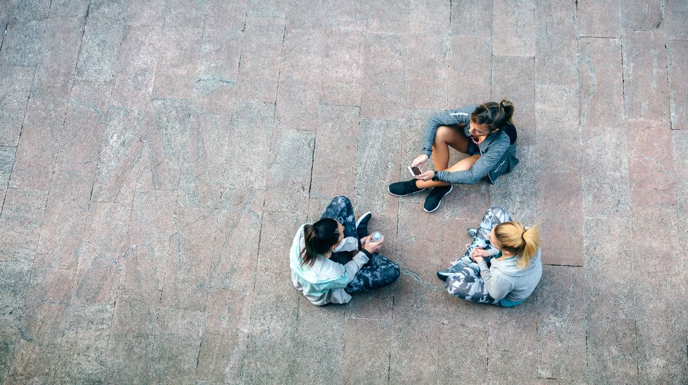 Female runners sitting on the ground after training