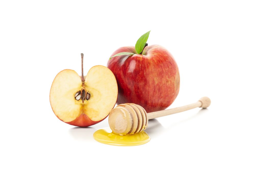 Side view of honey dipper, leaves and apples