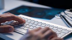 Doctor Typing on Keyboard in Office