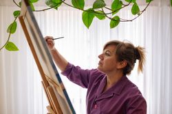 Adult woman painting canvas at home