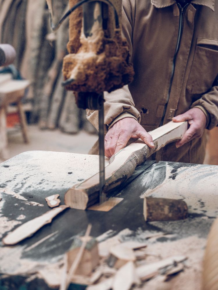 Faceless carpenter cutting wood with scroll saw