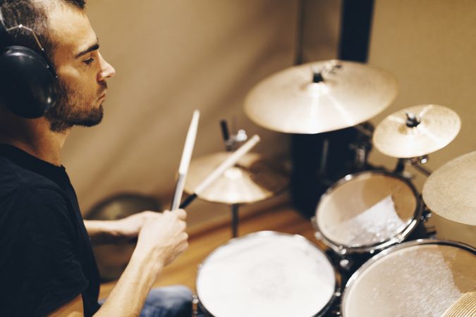 Man with headphones playing on drums