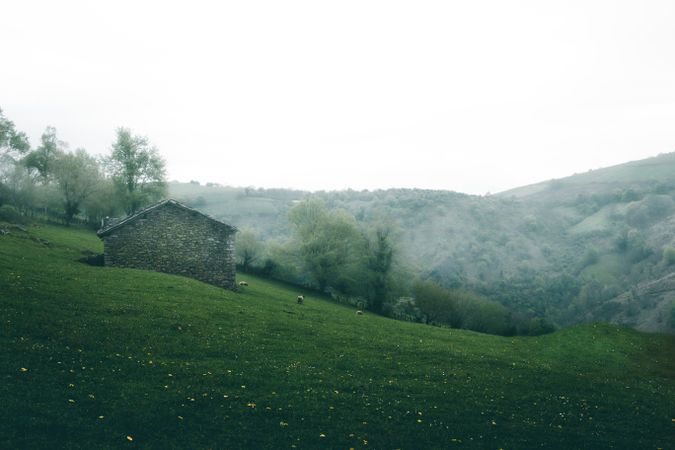 Stone house on hillside on foggy day