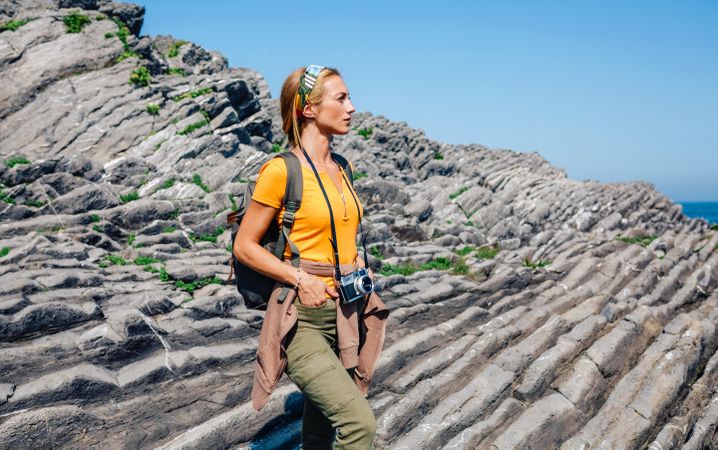 Woman enjoying view on an ocean hike with a camera