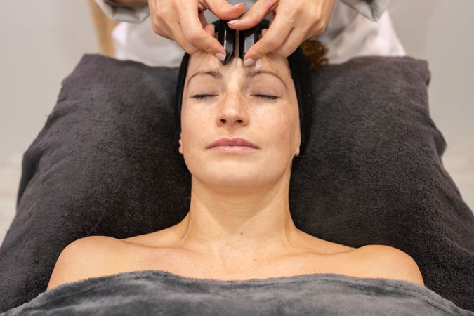 Woman having relaxing facial with forehead massage