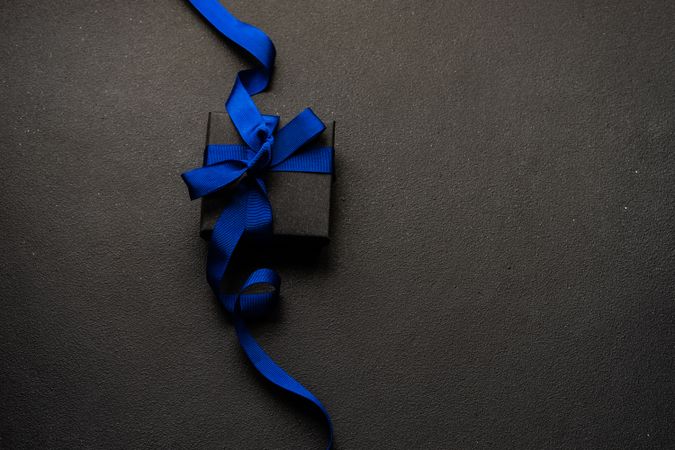 Present with blue ribbon on dark background