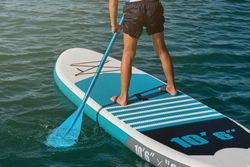 Faceless child on paddleboard in sea