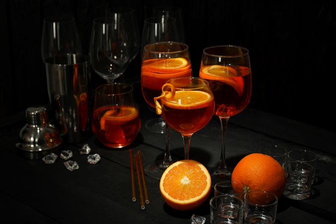 Wine glasses garnishes with orange slices on table with bar accessories