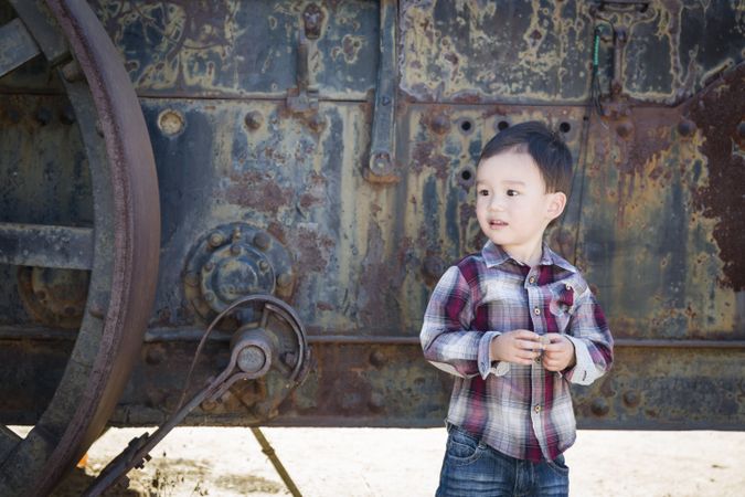 Cute Young Boy Having Fun Near Antique Machinery