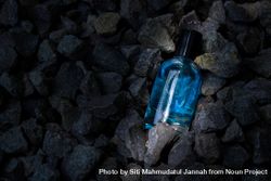 Light blue perfume bottle mock up laying in rocky terrain bDjPpV