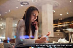 Young woman texting in a cafe 0JQvlb