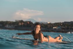 Smiling woman on surf board floating on water
