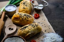 Traditional Georgian pies with chicken meat, bell pepper and herbs with flour and sieve