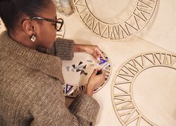 Black artist working with pliers and wood