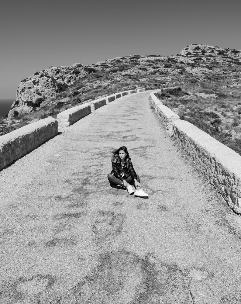 Woman sitting on stony path in countryside