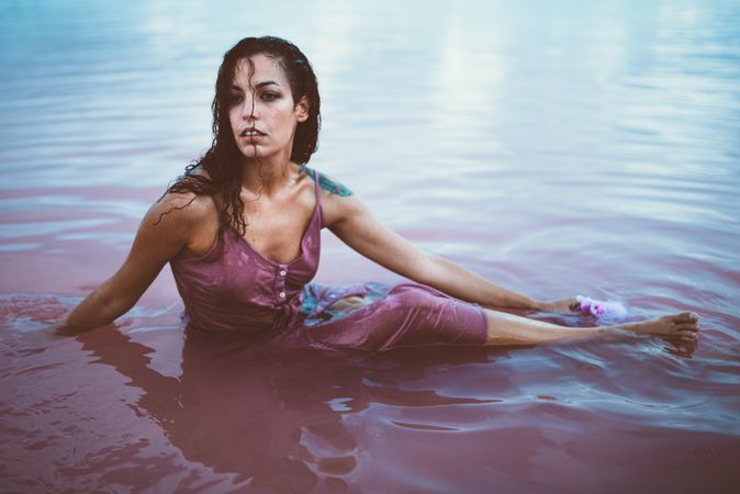 Woman in wet dress sitting in water