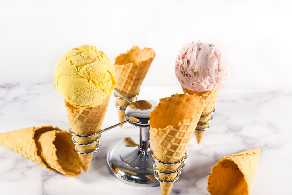 Ice cream cone stand with waffle cones and pink and purple scoops