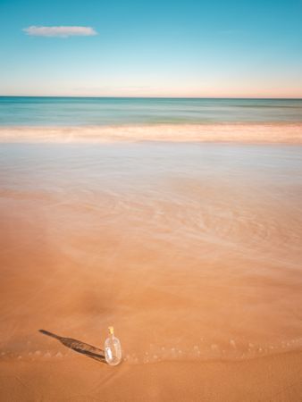 Bottle in sand near sea