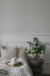 Bed with tray of coffee and glass vase with flowers