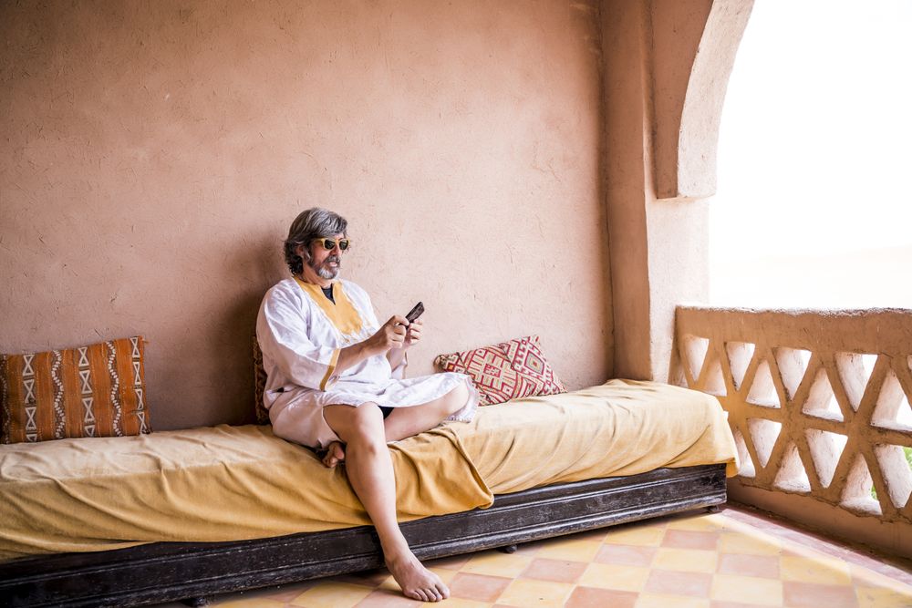Man with phone on oriental stone terrace