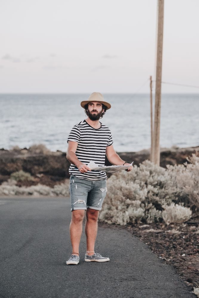 Male traveler standing with map