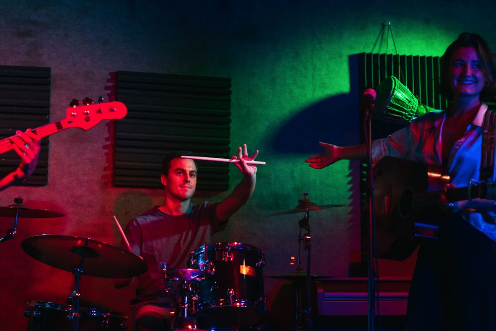 Musicians In Stage With Colorful Lights Performing In A Live Concert