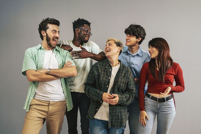 Group of diverse young friends laughing and having fun together in studio