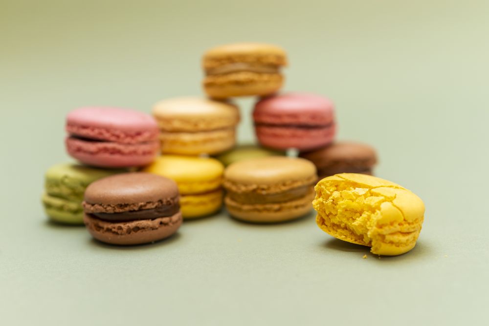 Colored tasty macaroons with a green background
