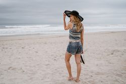Young female walking barefoot on sandy beach
