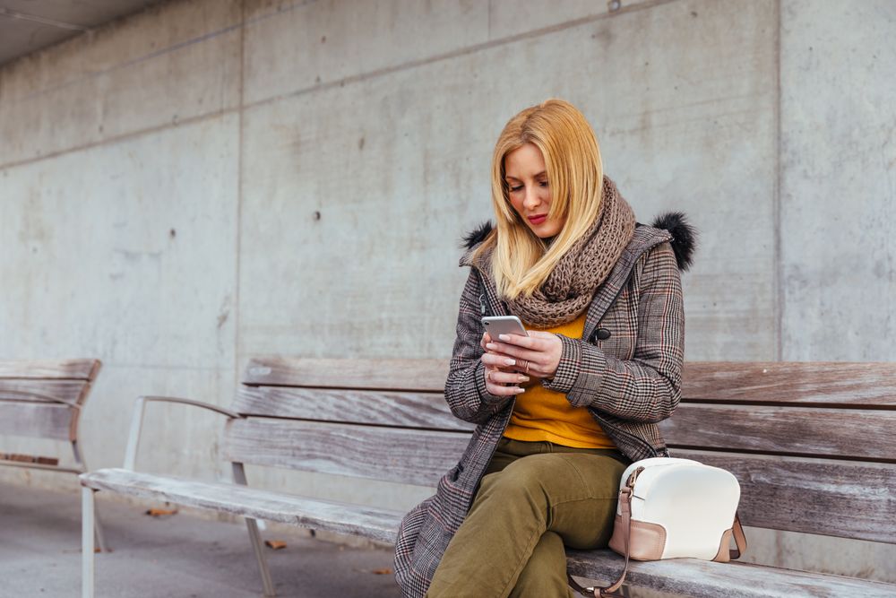 Portrait of blonde woman using her mobile phone