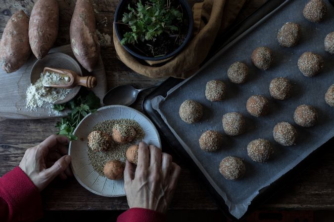 Person rolling in breadcrumbs sweet potatoes