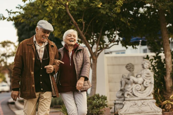 Older couple laughing and walking outdoors on winter day