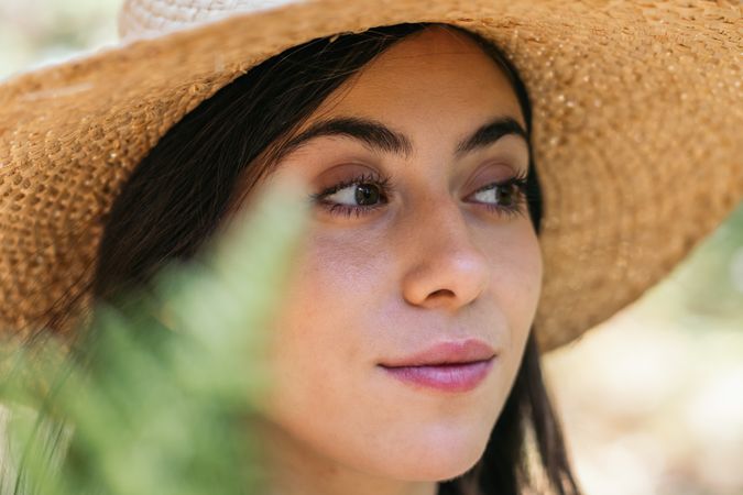 Portrait of a woman with a straw hat in the forest