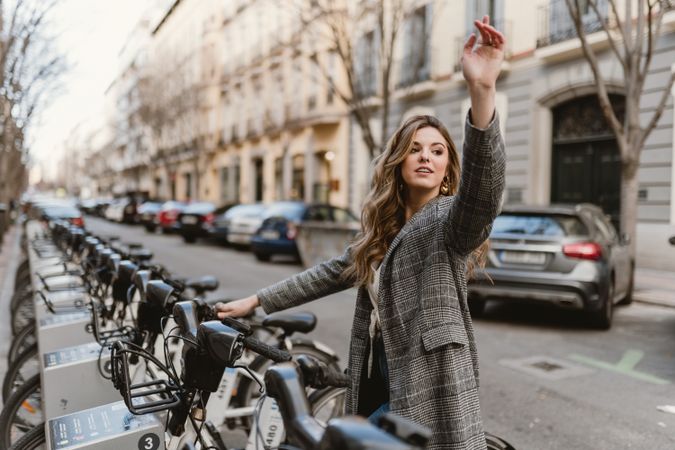 Woman choosing rental bicycle on parking lot