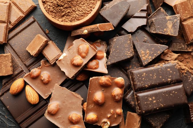 Chocolate, melted chocolate and almond on dark background