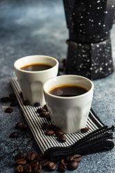 Cups of espresso on counter with moka