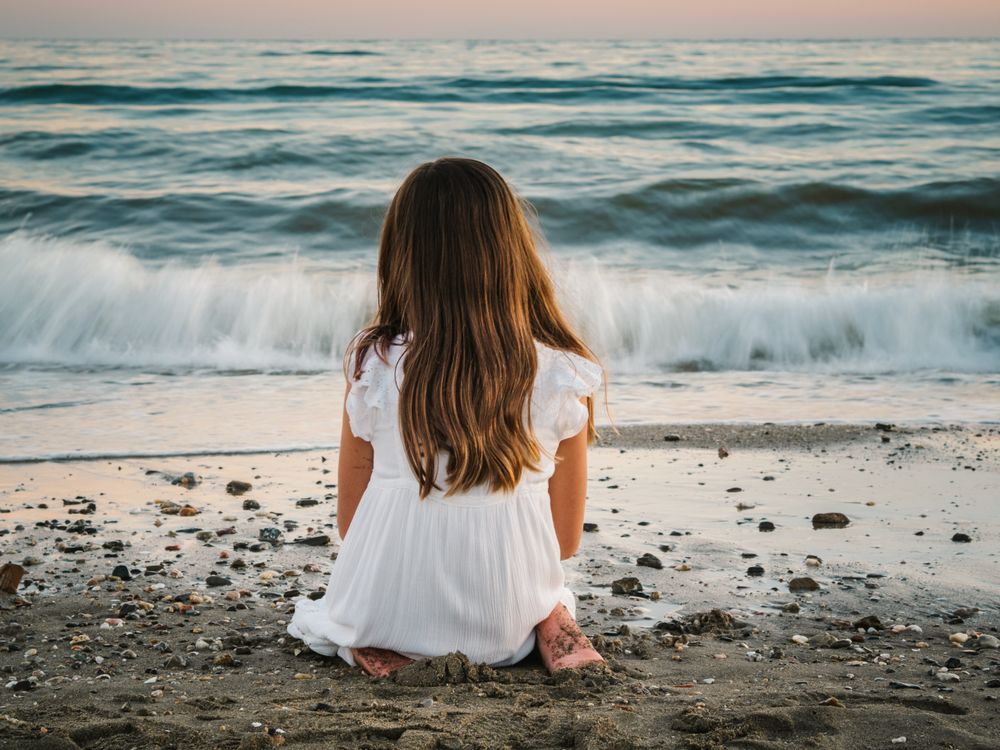 back view girl sitting on beach in daylight