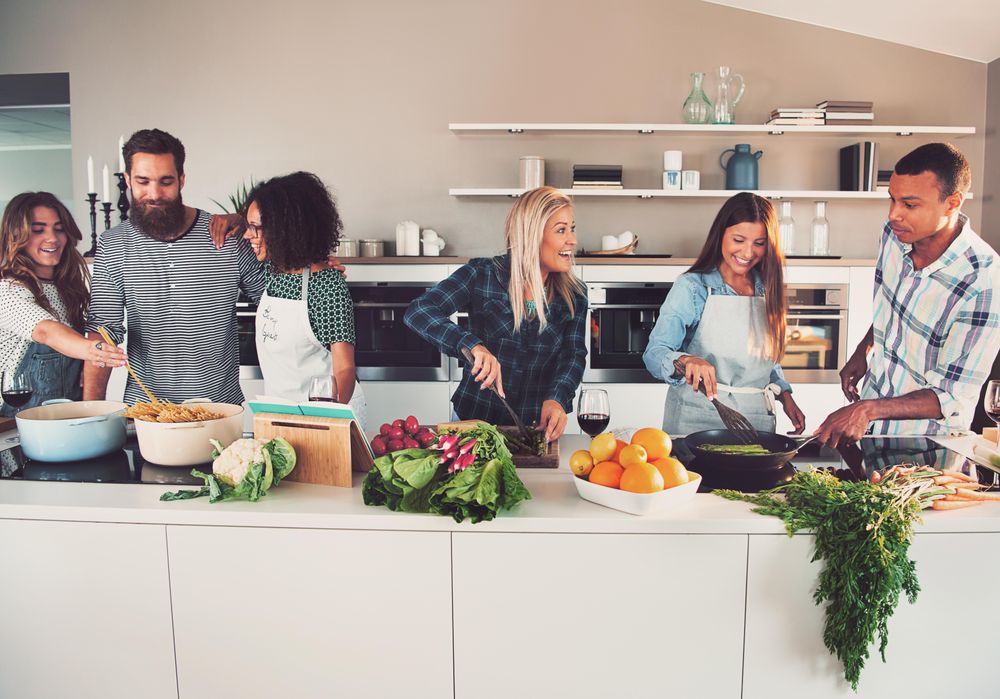 Multi-ethnic friends cooking together in the kitchen
