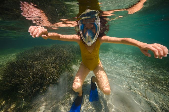 Unrecognizable adult in snorkeling mask in ocean