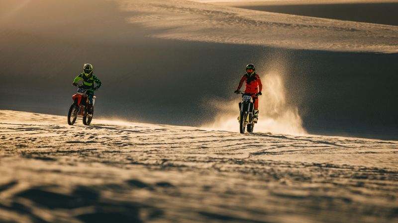 Dirt bikers racing on sand dunes
