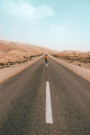 Person walking on a road in desert