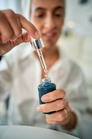 Crop woman with liquid facial essence